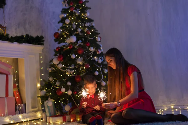 Мама и сын у елки с подарками новогоднего декора зимой — стоковое фото