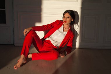 Ofiste kırmızı takım elbiseli esmer bir iş kadını portresi.