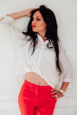 Ofiste kırmızı takım elbiseli esmer bir iş kadını portresi.