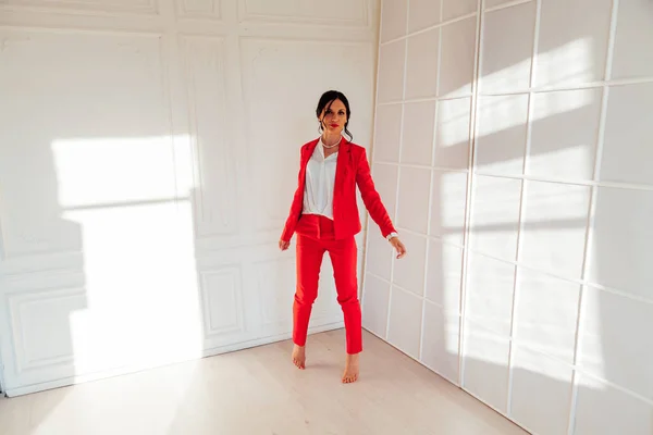 オフィスでの赤いビジネススーツのビジネス女性ブルネットの肖像 — ストック写真