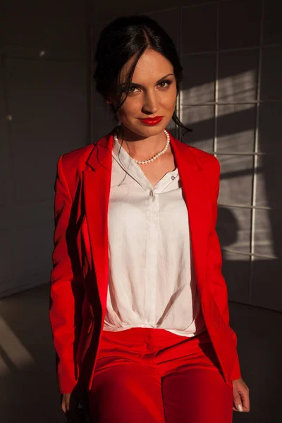 Πορτρέτο μιας γυναίκας επιχειρηματία μελαχρινή σε ένα κόκκινο κοστούμι επιχείρησης στο γραφείο — Φωτογραφία Αρχείου