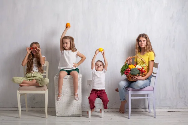 Ragazzo e tre ragazze con un cesto di verdure e frutta — Foto Stock
