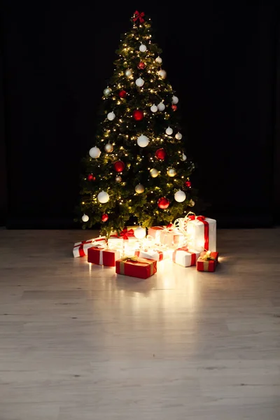 Árbol de Navidad con guirnaldas de luces y regalos de Año Nuevo — Foto de Stock