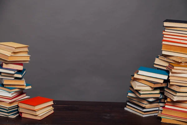 stacks of educational books against the background of the wall in the library