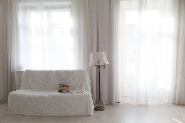Sofá blanco con libros en el interior de la habitación blanca — Foto de Stock