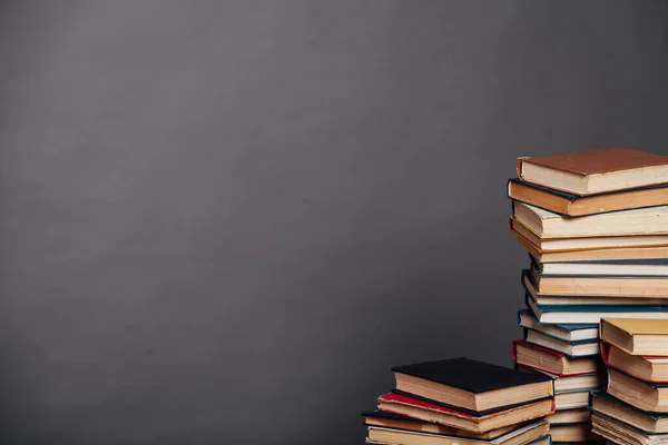 Staplar av läroböcker mot bakgrund av väggen i biblioteket — Stockfoto