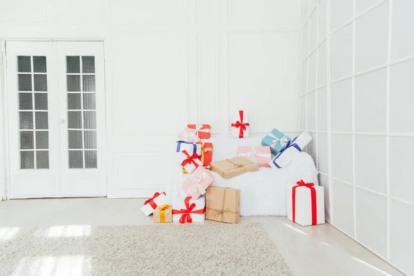 Білий диван з подарунками на свято в інтер'єрі білої кімнати — стокове фото