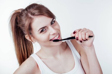 Güzel kız beyaz diş fırçası gülüşünü temizler.