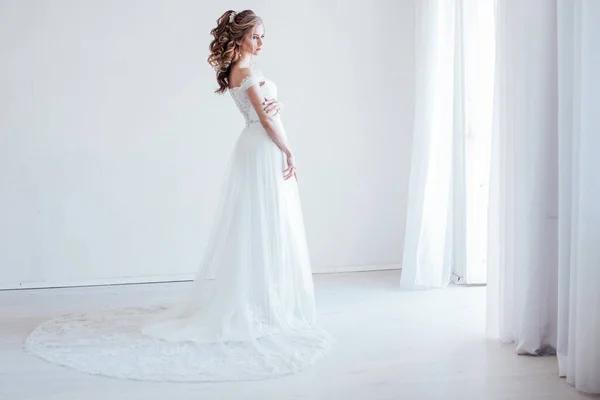 Panna młoda w sukni ślubnej w białym pokoju — Zdjęcie stockowe