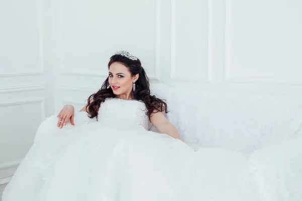 Noiva em vestido de noiva sentado no sofá — Fotografia de Stock