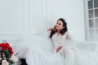 Gelin bir kanepede oturan gelinlik