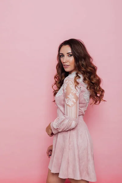 Portrait of a beautiful fashionable woman with locks in a pink dress — Stock Photo, Image