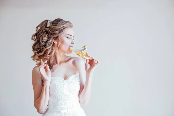 La novia en una boda en el vestido de novia comiendo chocolate —  Fotos de Stock