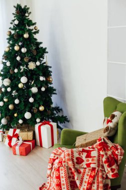 Beyaz odanın içinde hediyeleri olan yeşil Noel ağacı.