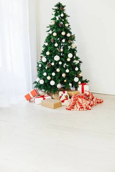 Grüner Weihnachtsbaum mit Geschenken im Inneren des weißen Zimmers Neujahr — Stockfoto