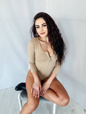 Siyah saçlı, şık, esmer bir kadının portresi.