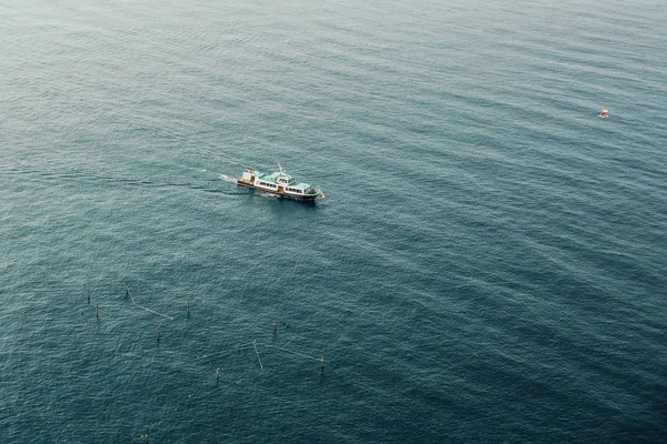 Um barco navega no mar azul na baía — Fotografia de Stock