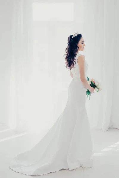 Noiva em vestido de noiva branco com um buquê de flores — Fotografia de Stock