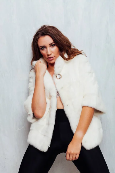 Retrato de uma bela mulher na moda com cachos em um casaco de pele — Fotografia de Stock