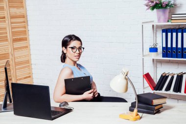 bir bilgisayarda Office kağıt klasörlerde iş kız oturuyor