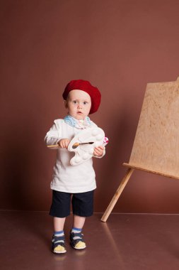 küçük çocuk sanatçı fırça ve boya boya bir resim
