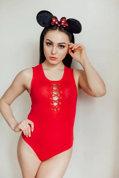 Модная девушка в красном теле позирует на сером фоне — стоковое фото