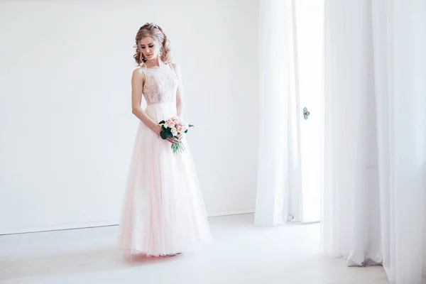 Nevěsta v růžových svatebních šatech a kytice květin — Stock fotografie