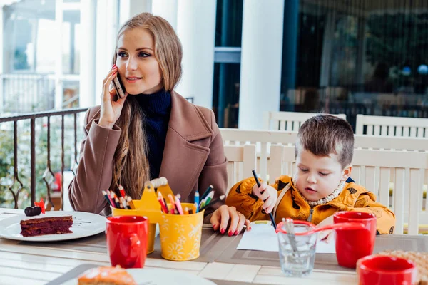 Restaurant mom with son talking on the phone