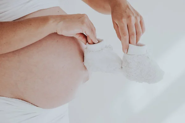 孕妇的胃和婴儿的东西袜子1 — 图库照片