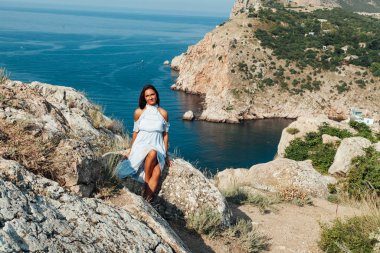 Uzun saçlı güzel bir kadın güzel bir deniz manzarasında seyahat eder.