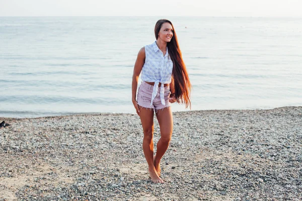 Mooie vrouw met lang haar wandelingen op het strand aan zee — Stockfoto