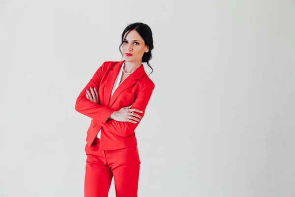 Retrato de uma bela mulher morena na moda em um terno de negócios vermelho no escritório — Fotografia de Stock