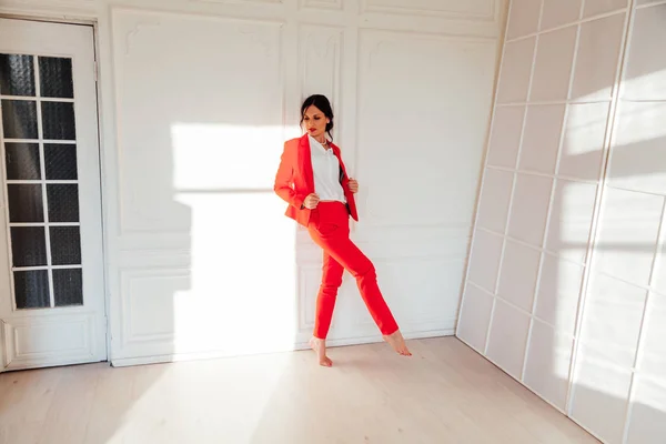 Retrato de una hermosa mujer morena de moda en un traje de negocios rojo en la oficina —  Fotos de Stock