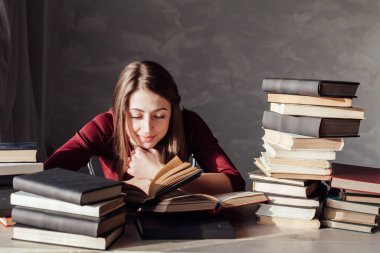 Kız okuma kitabı kütüphanede sınava hazırlar