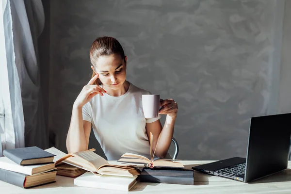 Девушка читает книгу и пьет кофе — стоковое фото