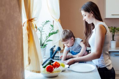 küçük çocuk anne mutfakta yardımcı oluyor