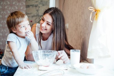 Anne ve genç oğlu mutfakta bir pasta hazırlamak