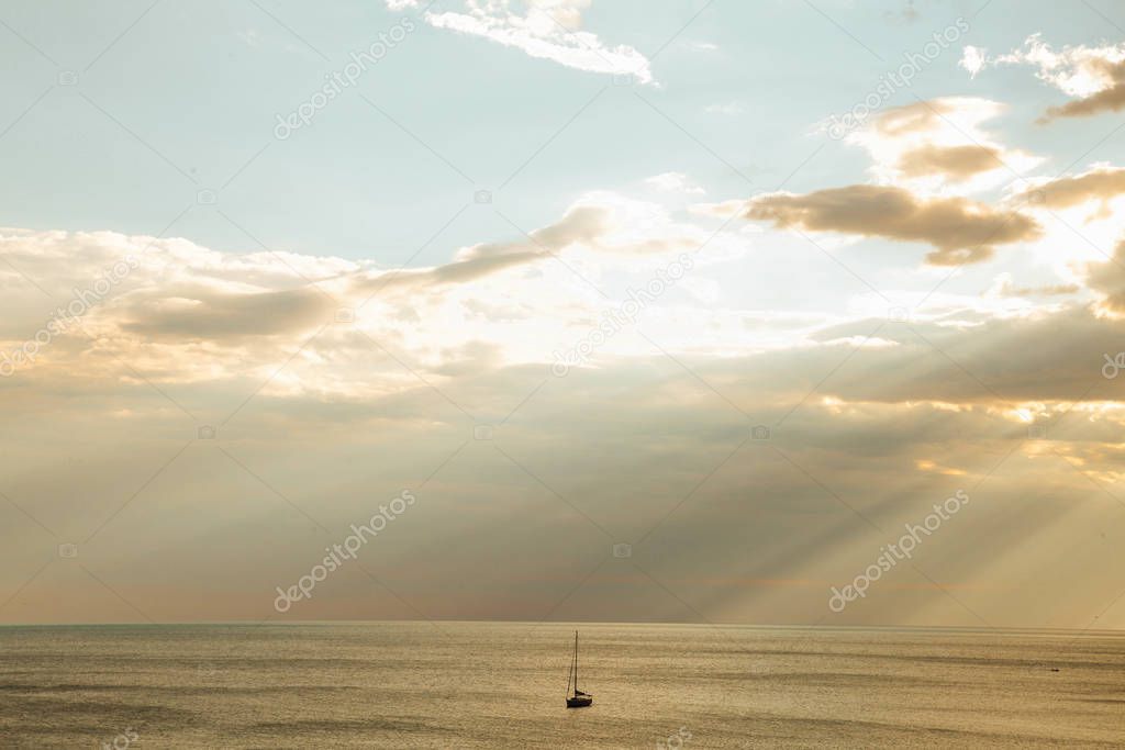 yacht in the sea rays from clouds landscape