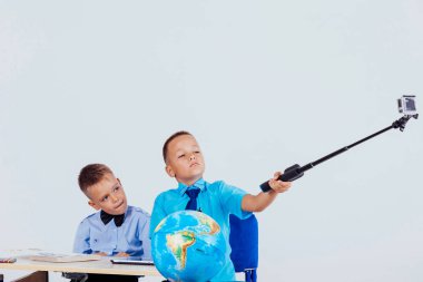 the two boys are photographed at the school at the table clipart
