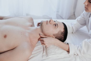 Erkek masör masaj yapıyor. Spa 'da boyun terapisi yapıyor.