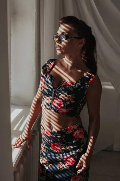 Dívka v brýlích stojí u okna obchodní módy — Stock fotografie