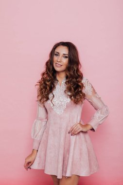 Pembe elbiseli, saçları kıvırcık güzel bir kadının portresi.