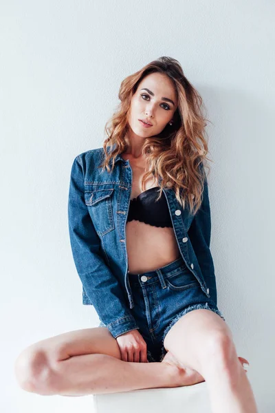 Portrait of a beautiful fashionable woman in lingerie and denim shorts — ストック写真