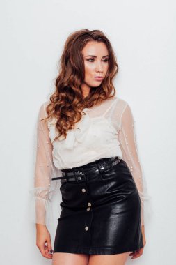 Güzel, şık bir kadının portresi. Bluz ve siyah etekli, kıvırcık saçlı.