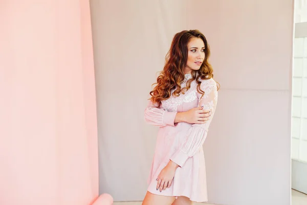 Porträt einer schönen modischen Frau mit Locken in einem rosa Kleid — Stockfoto