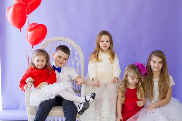 Ragazzo e ragazze con palloncini rossi a forma di cuore in vacanza — Foto Stock