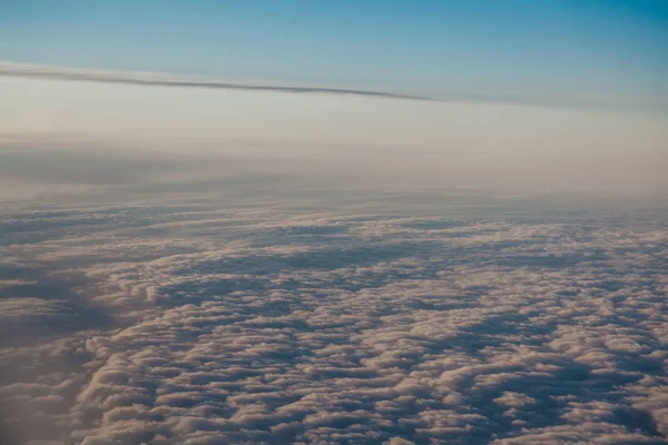 Volant au-dessus des nuages au coucher du soleil depuis un avion — Photo