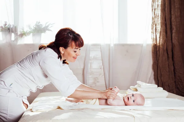 Мать маленького мальчика делает массаж рук и ног — стоковое фото