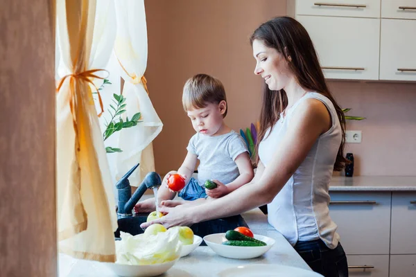 Kitchen mom son wash fruits and vegetables — Stock Photo, Image