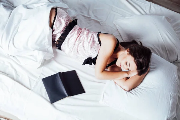 Chica en pijama acostada en la cama con un libro antes de acostarse —  Fotos de Stock